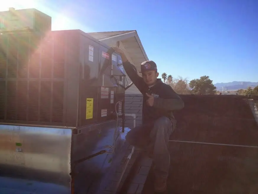 HVAC technician performing AC Tune-Up on a rooftop unit in West Hempfield