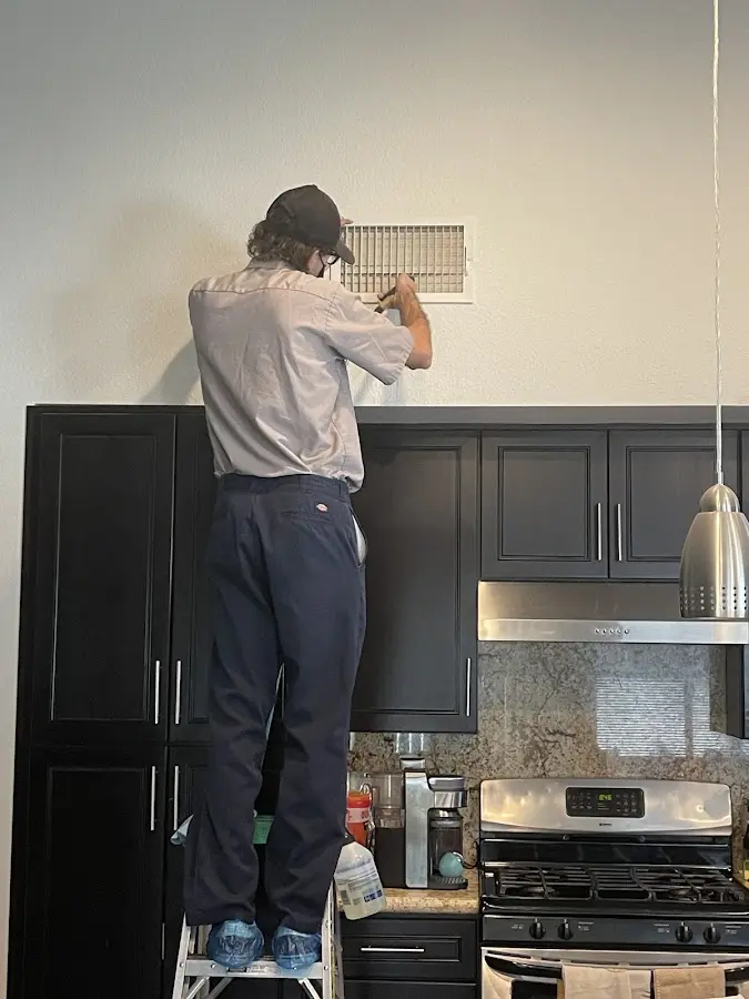 Technician inspecting an air vent during HVAC service in West Hempfield